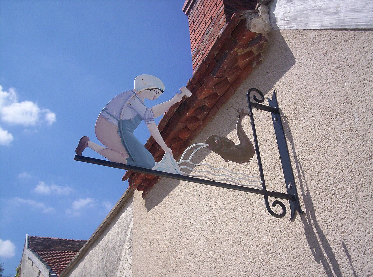 Enseigne en fer forgé sur le lavoir d'Hautvillers, en Champagne — motif figuratif représentant un lavandier
