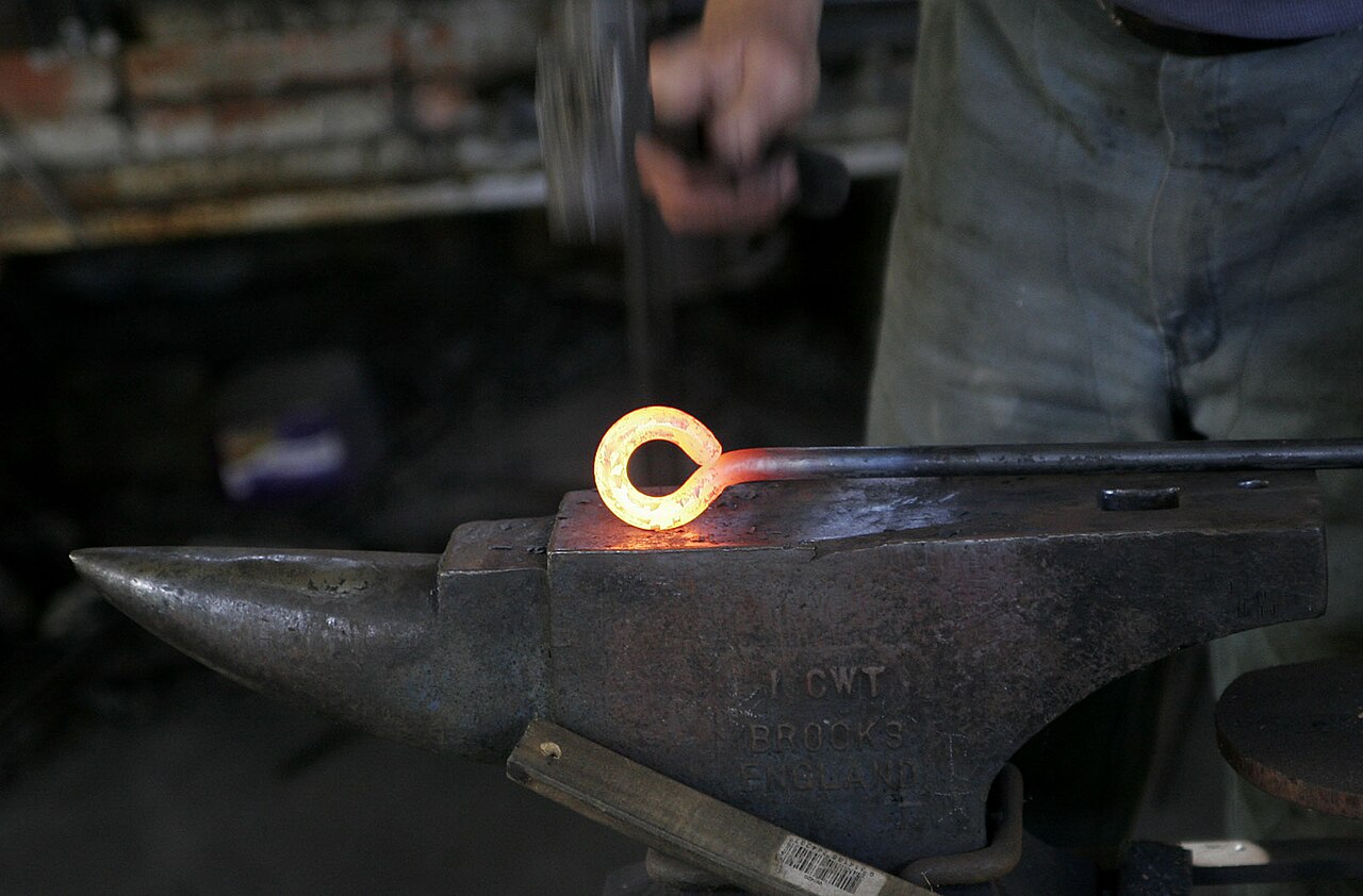 Volute de fer chauffée au rouge martelée sur l'enclume d'un atelier de ferronnerie