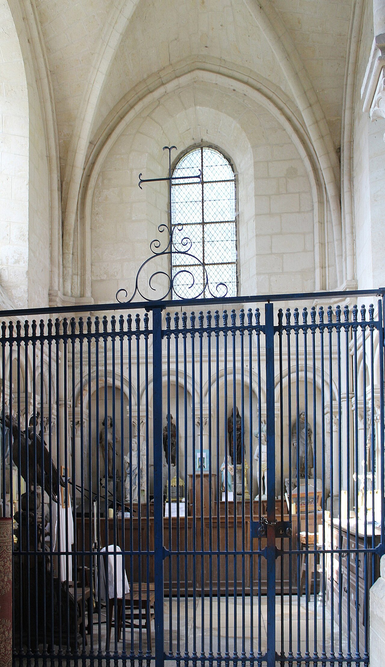 Grille de clôture en fer forgé à barreaux et volutes dans une église ancienne