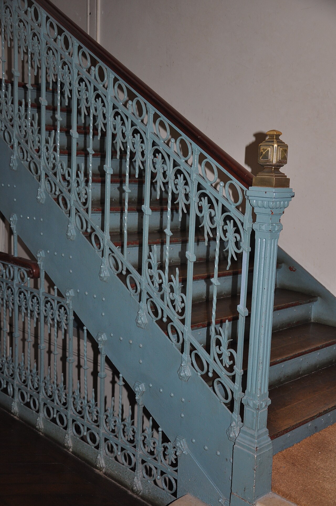 Rampe d'escalier ancienne en fer forgé à motifs de volutes et rosaces